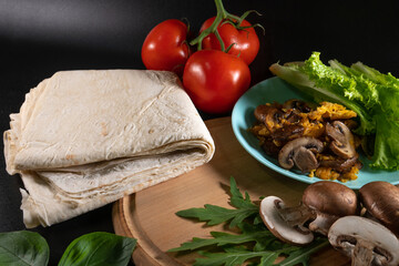 Georgian lavash and shawarma ingredients. Cooking concept. Baking and fast food. Mushrooms, cheese, grilled meat, tomato and cucumber. Vegetables and sauce.