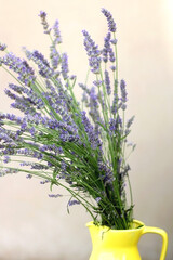 Naklejka premium Yellow vase with fresh lavender flowers. Selective focus.