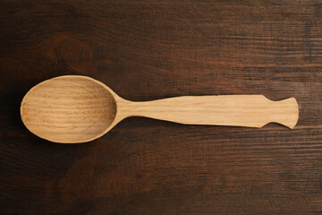 Handmade wooden spoon on rustic table, top view