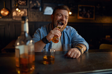 Man opens bottle of beer with his teeth in bar