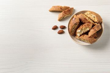 Traditional Italian almond biscuits (Cantucci) on white wooden table, flat lay. Space for text