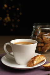 Tasty cantucci and cup of aromatic coffee on wooden table. Traditional Italian almond biscuits