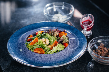 Prepare a delicious fresh salad of tomato greens, cheese, veal and cashew nuts. Delicious healthy food.