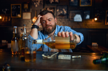 Drunk man pours alcohol at the counter in bar