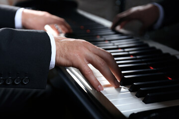 Fototapeta premium Man playing grand piano, closeup. Talented musician