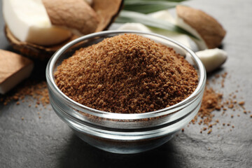 Natural coconut sugar in glass bowl on black table