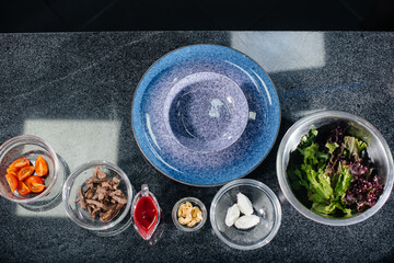 Prepare a delicious fresh salad of tomato greens, cheese, veal and cashew nuts. Delicious healthy food.