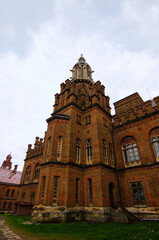 Fototapeta na wymiar Ancient brown brick building of Chernivtsi University against rainy sky. UNESCO World Heritage Site. Travel and tourism concept. Selective focus with wide angle lens
