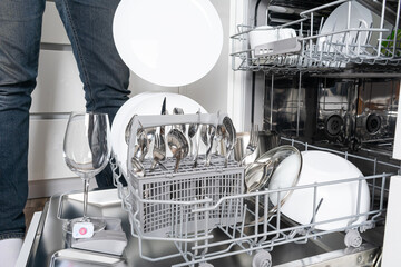 Dishes and cutlery on dishwashing machine. Clean dishes