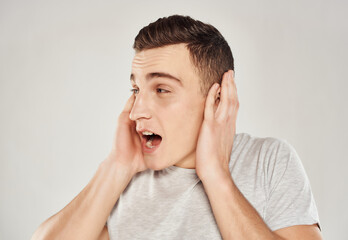 emotional man holding his face but lifestyle close-up light background