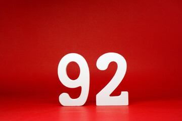Ninety Two ( 92 ) white number wooden on Red Background with Copy Space - New promotion 92% Percentage , Birthday anniversary , Business finance Concept  - obrazy, fototapety, plakaty
