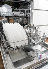 Dishes and cutlery on dishwashing machine. Clean dishes