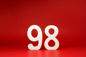 Ninety Eight ( 98 ) white number wooden on Red Background with Copy Space - New promotion 98% Percentage , Birthday anniversary , Business finance Concept 