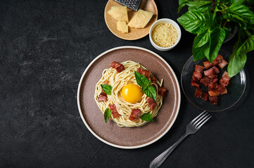 Fototapeta na wymiar Traditional Italian Pasta Carbonara with bacon, cheese and egg yolk on plate on dark background. Top view Flat lay