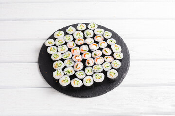 Set of sushi rolls on black plate