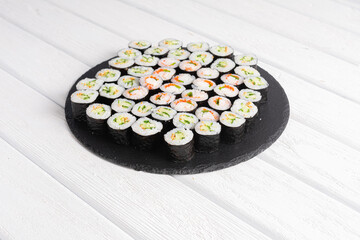 Set of sushi rolls on black plate