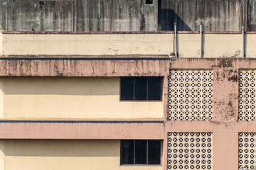 The exterior facade of the walls of an old weathered apartment building in suburban Mumbai.