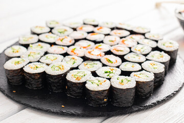 Set of sushi rolls on black plate