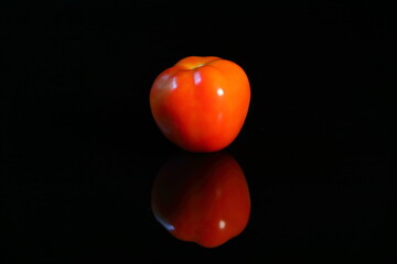 Fresh red tomato on dark background with reflex