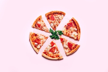 Top view with a sliced pizza on pink background.