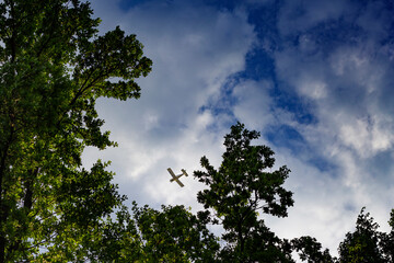 Obraz premium small plane in the blue sky. view from the ground