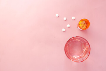  white color medical pills spilling on pink , top view 