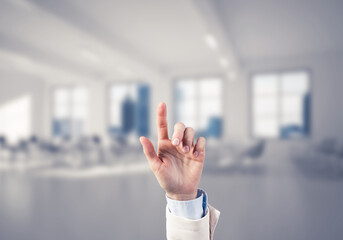 Choosing gesture of businessperson in elegant modern interior in sunshine light