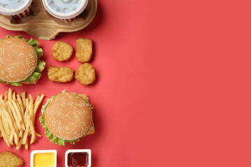 Flat lay composition with delicious fast food menu on red background. Space for text