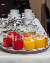 Apple, peach and tomato juice. Glasses of juice on a tray.
