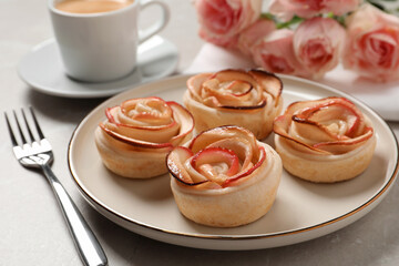 Obraz na płótnie Canvas Freshly baked apple roses served on light table. Beautiful dessert