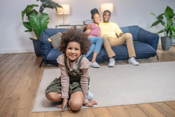 Daughter on floor and hugged parents on couch