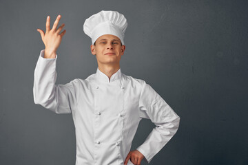 Naklejka premium Cheerful man in chef's uniform raises his hand Gourmet restaurant