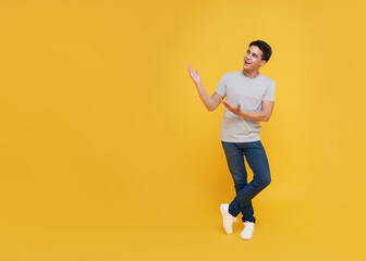 Fototapeta na wymiar Young handsome Asian man standing with his finger pointing isolated on yellow background with copy space. panoramic background.