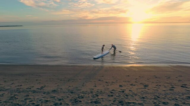 Aerial view Man and young girl on a Paddleboard