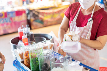 Obraz na płótnie Canvas Vendor selling ice cream to customers in the fresh market