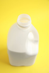 Gallon bottle of milk on yellow background