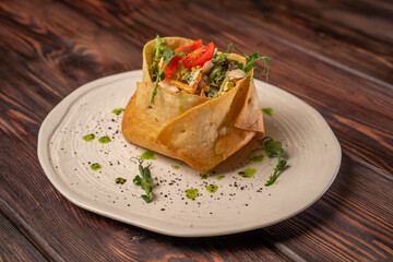 Tortilla with chicken fillet on a beautiful white flat plate