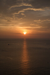 Beautiful, stunning panoramic view of the golden sky and reflections on the Andaman sea during the sunset at Promthep Cape landmark viewpoint in Phuket,