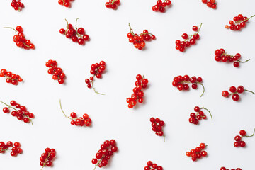 Pattern of red currants isolated on a bright white background. Red currant clusters, healthy diet. Creative fruit food concept. Flat lay, top view.