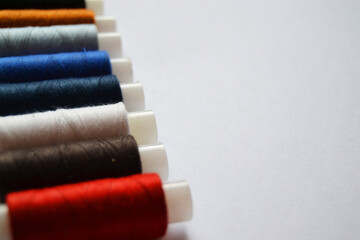 Multicolored spools of thread on a white background