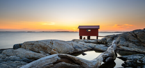 a colorful sunset of a red little fisherman's hut at the coast of sweden. Longe exposure © Johannes