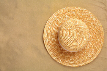 Fototapeta na wymiar Stylish straw hat on sand, top view. Space for text