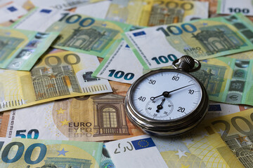 A stopwatch on mixed euro notes as a background