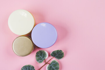 Obraz na płótnie Canvas Mockup cosmetic jar with cream or lotion and leaf isolated on pink background, mock up package for advertising, skincare or cosmetology, top view, flat lay, skin care and treatment with product.