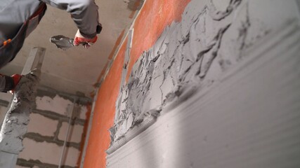 Workers are plastered walls. Hand plasterer at work. Application of the plaster on the wall....