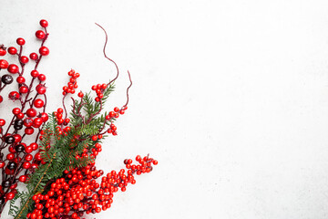 Christmas holidays composition with christmas decorations, red berries branches on white background with copy space, top view