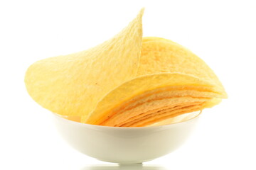 Several fragrant potato chips in a white earthenware dish, close-up, isolated on white.