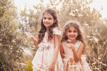 Two sisters playing and posing in nature - obrazy, fototapety, plakaty
