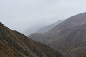 Mountains in the fog. Fall. Overcast. Ile-Alatau mountains, Almaty region, Kazakhstan.