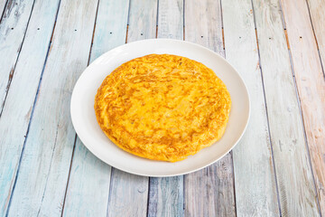 Fine potato omelette to share in a tapas restaurant on wooden table